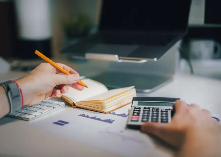 Mains tenant un crayon et une calculatrice